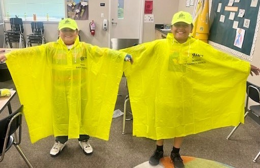 Two students wearing yellow ponchos