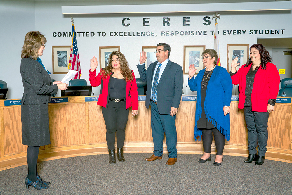 Four Trustees raise right hands and repeat Oath of Office read by Superintendent