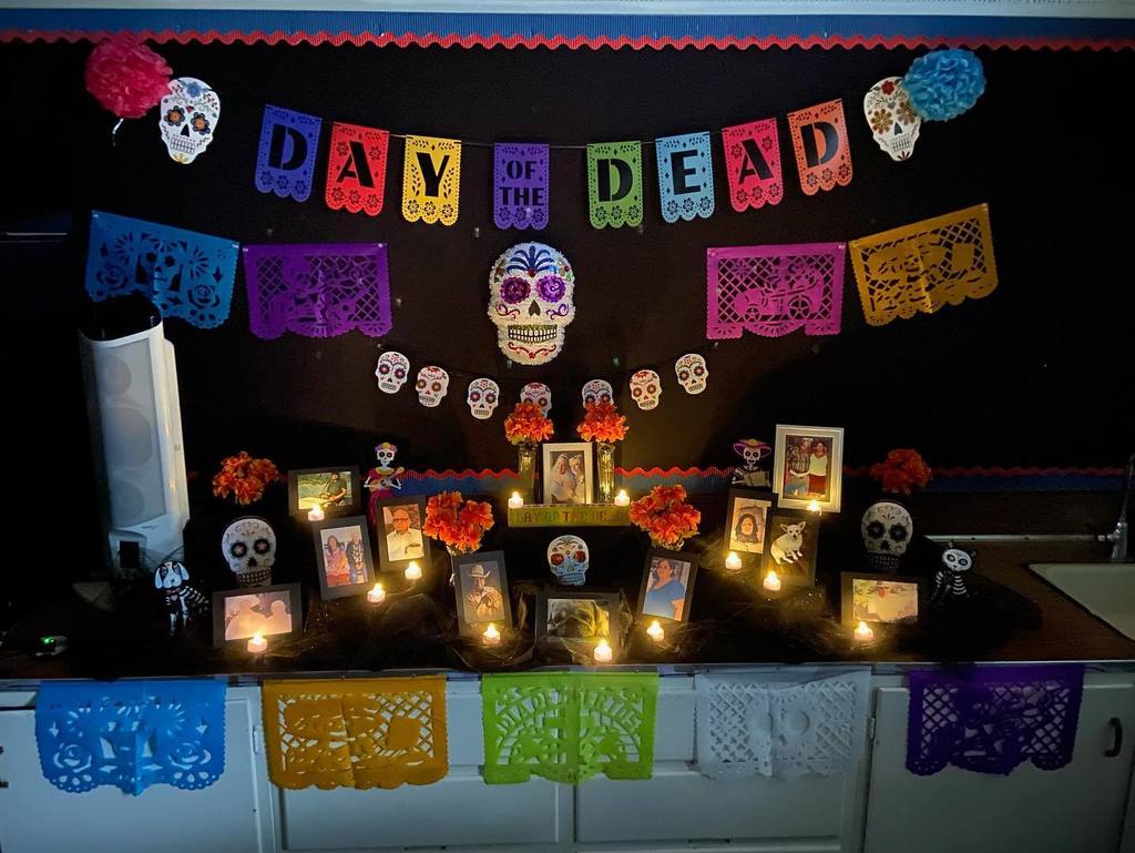 Day of the Dead table set up with colorful decorations and candles