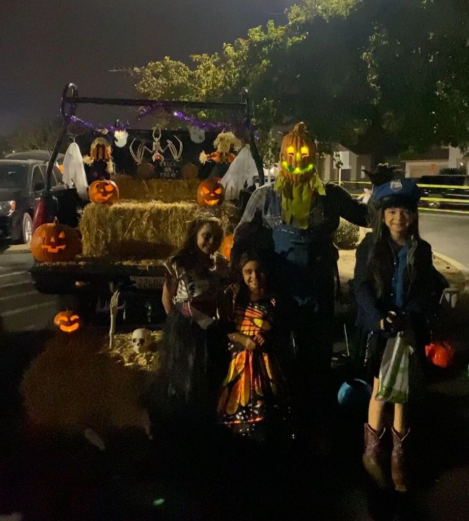 students on halloween trick or treating in front of hay ride