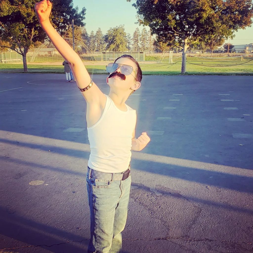 student dressed up as freddy mercury in parking lot