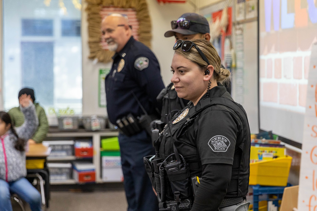 Three police officers at front of first-grade classroom
