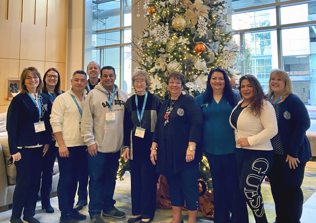 Board members in front of a Christmas tree at CSBA conference