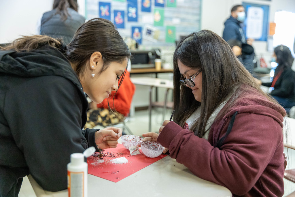 Two female students work together on holiday craft