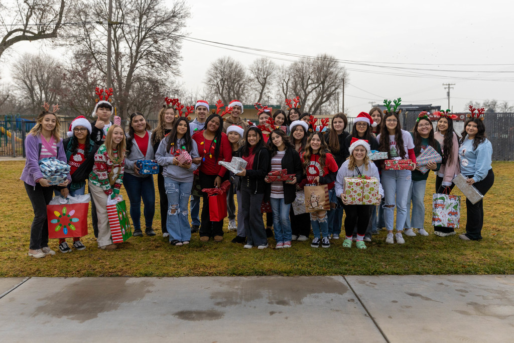 Group of CHS and Westport students gathered on school lawn holding gifts