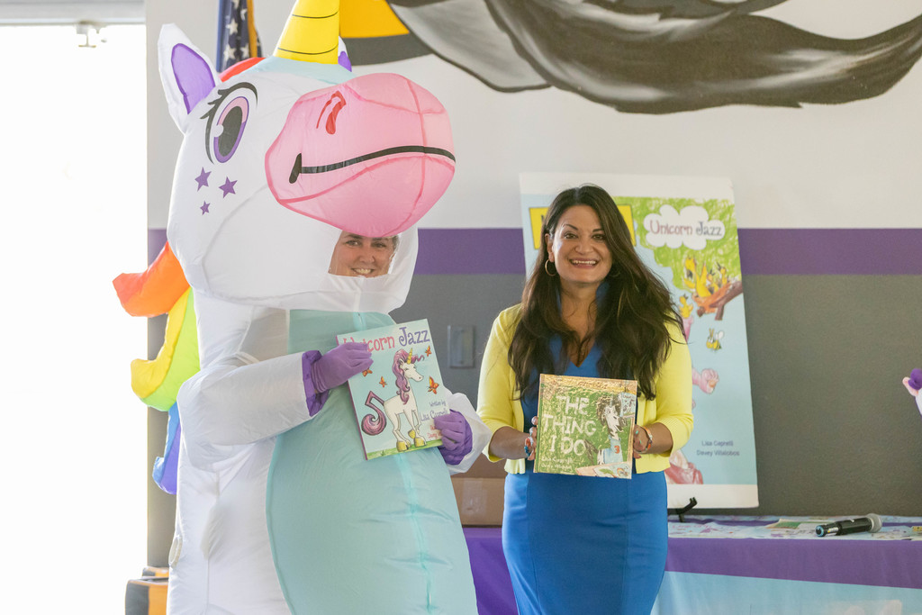 Author Lisa Caprelli stands next to a unicorn