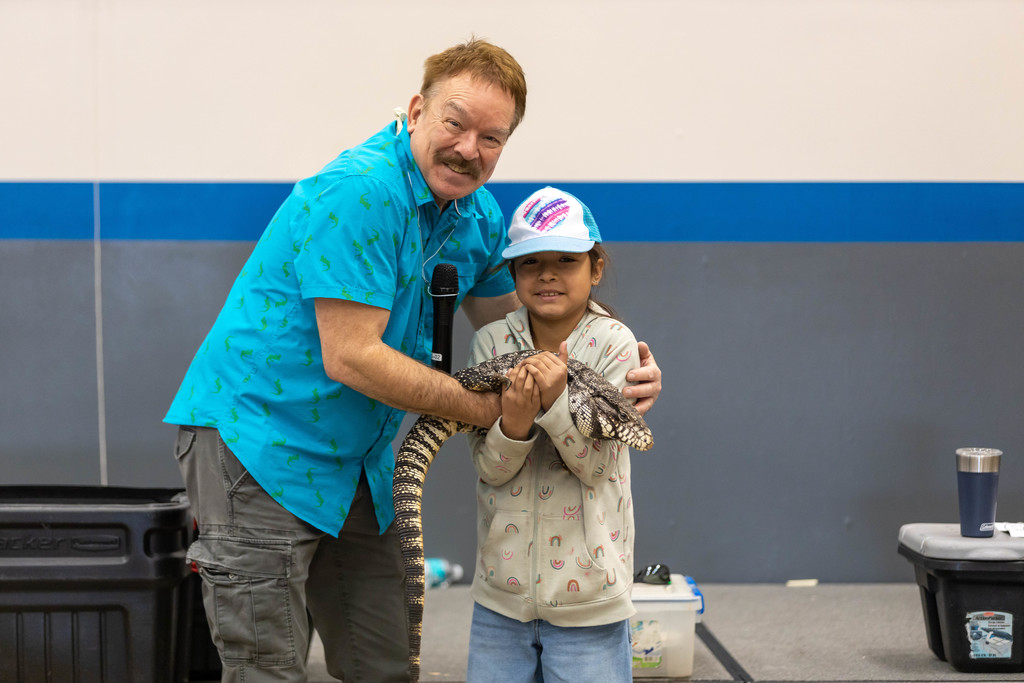 Boy holds reptile with help from Python Ron