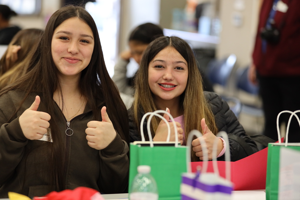 Two female students give thumbs-up