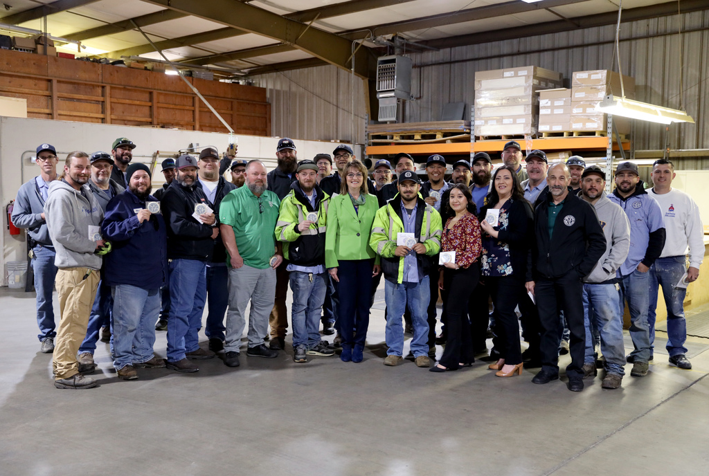 Dr. Wickham with large group of Maintenance employees in warehouse