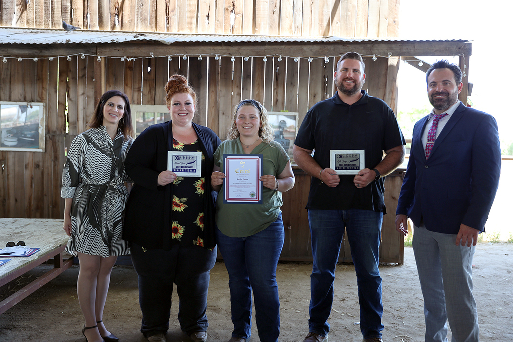 Honorees hold plaques, certificates