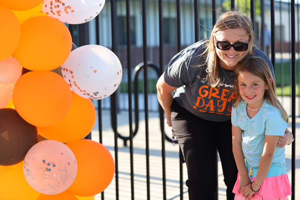 PKB Principal with young student near orange balloons