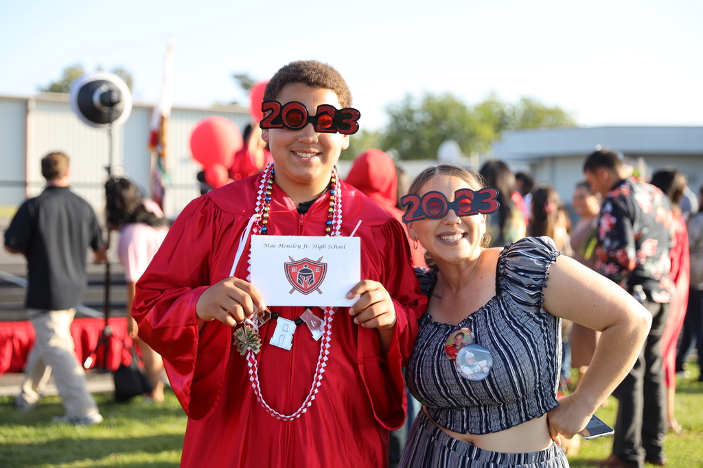 Mae Hensley student and his mom pose holding promotion certificate and wearing 2023 glasses