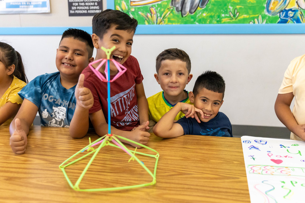 Smiling students built structure with Strawbees