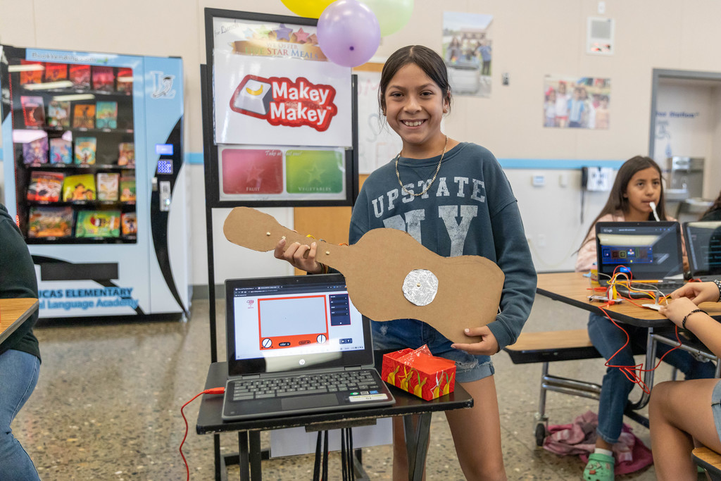 Female student plays cardboard guitar