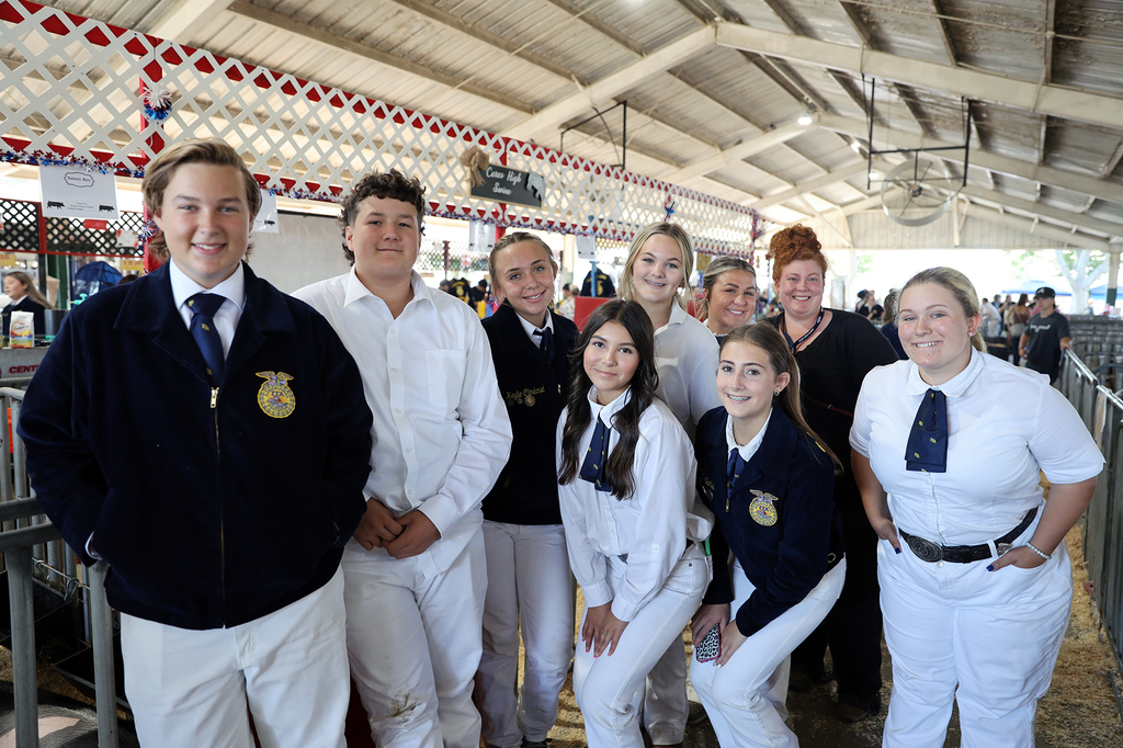 FFA students and advisor pose in swine barn