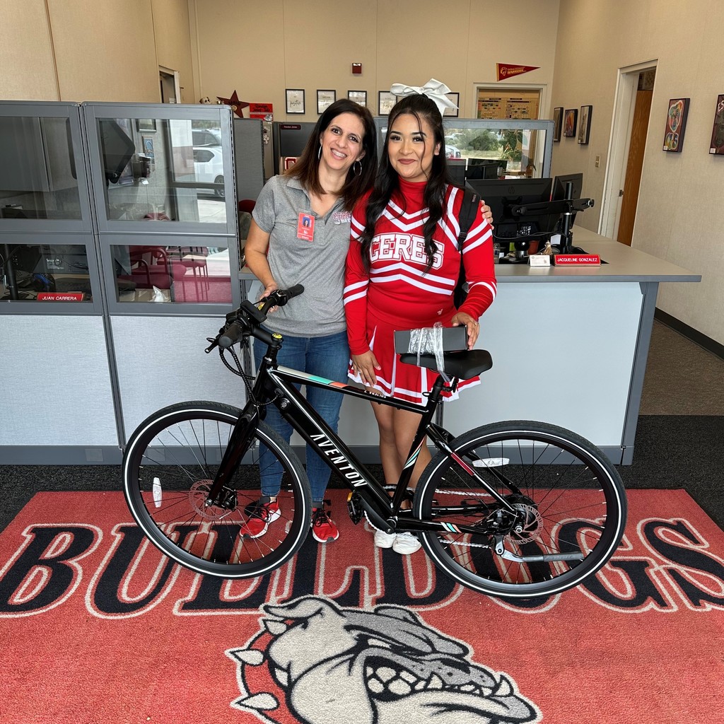 Principal in school office with student in front of bicycle