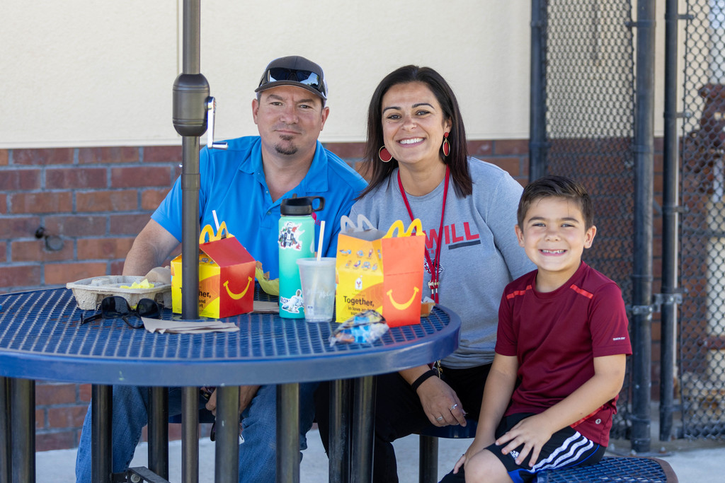 Little boy having lunch with parents at outdoor table