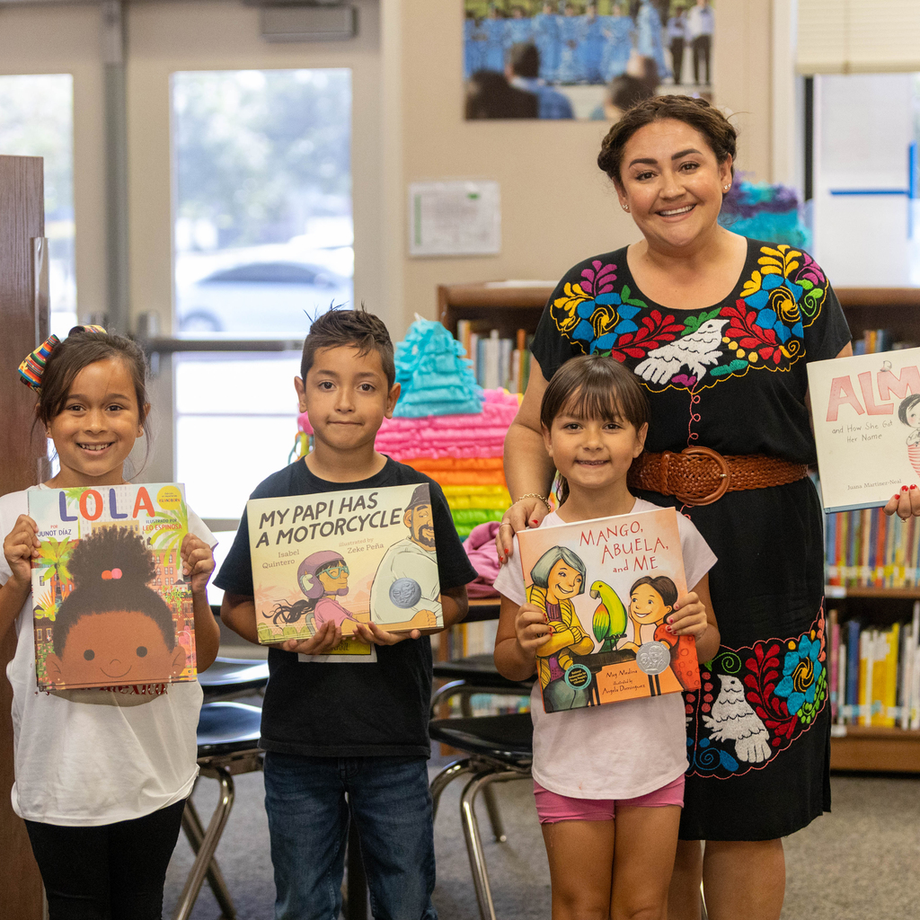 Students and principal hold books