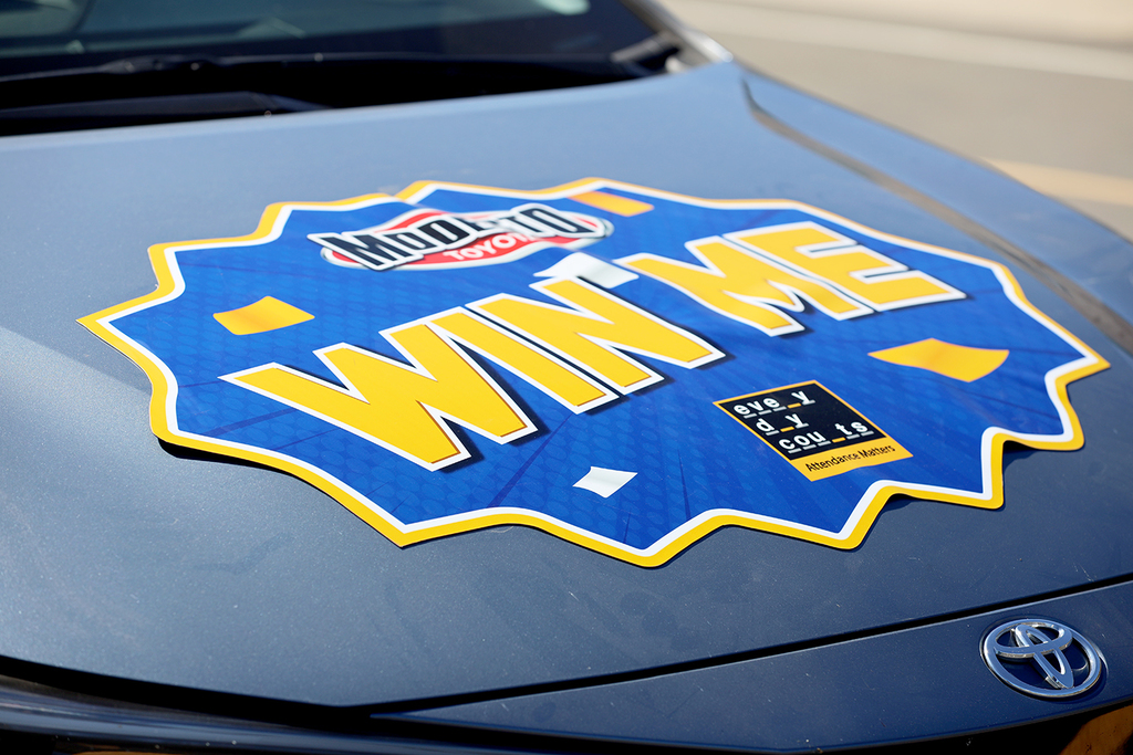 Win Me sticker on hood of Toyota Corolla